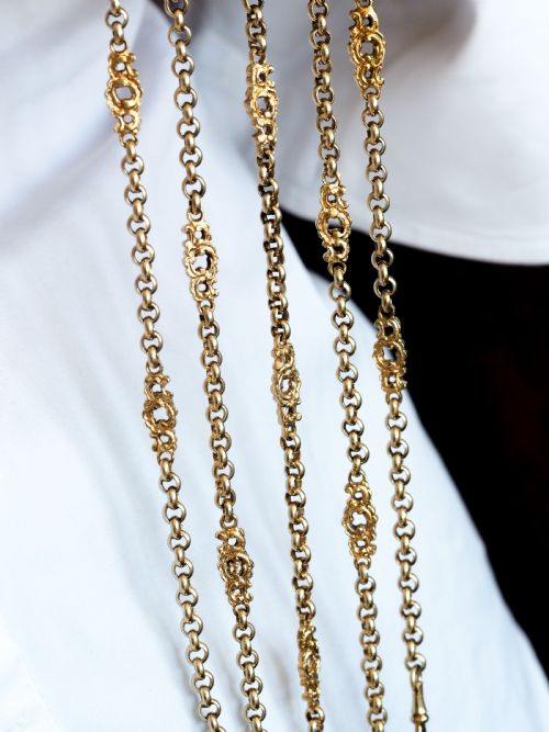 fig 7. An ornate Victorian silver-gilt chatelaine featuring five hanging chains with swivel clips and a rococo plaque detailed with a central cherub motif.