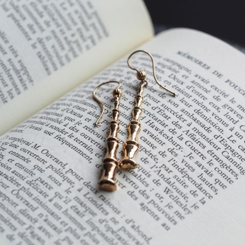 fig 5. A pair of 9ct yellow gold drop earrings designed with stacked bamboo node motifs hanging from shepherd hook ear wires.