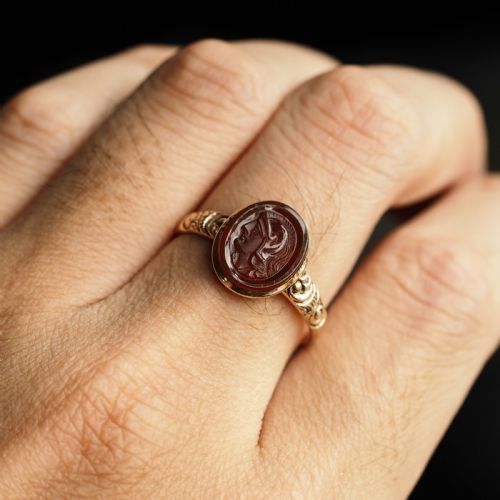 fig 7. A Georgian gold ring featuring an oval reddish-brown carnelian stone engraved with the profile profile of a helmeted Roman soldier.