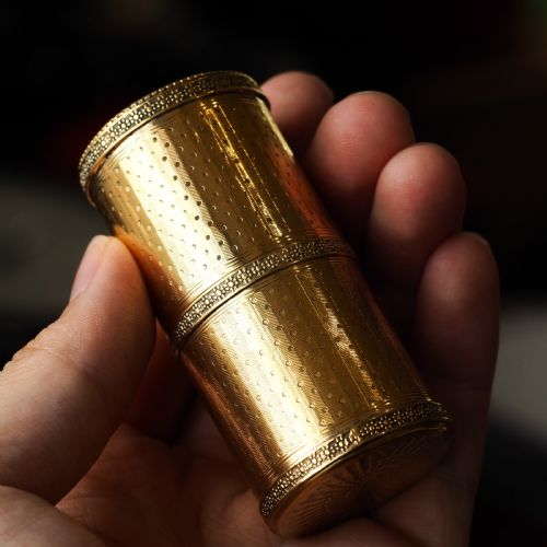 fig 2. A small cylindrical French silver gilt etui featuring intricate engine-turned guilloche wave patterns and textured borders.