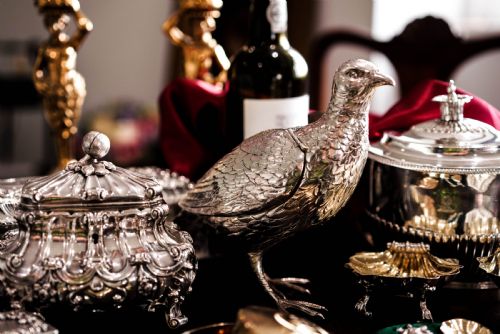 fig 5. A solid silver model of a partridge with chased feather detailing standing on two feet with a hinged compartment lid along its back.