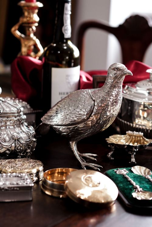 fig 8. A solid silver model of a partridge with chased feather detailing standing on two feet with a hinged compartment lid along its back.