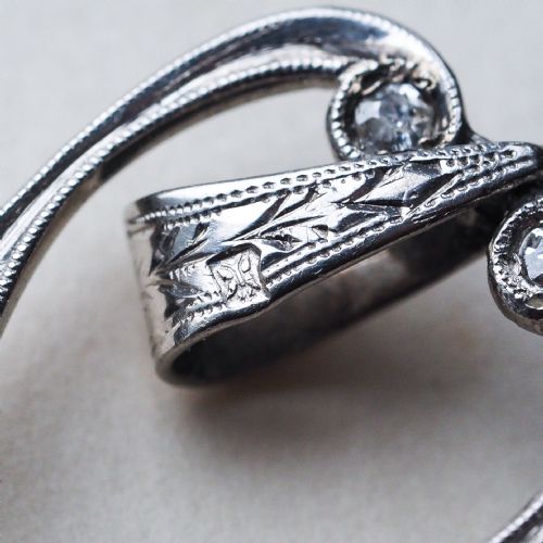 fig 7. An Art Deco platinum lorgnette featuring a circular folding magnifying glass lens attached to a geometric handle set with small diamonds.