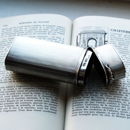 fig 3. An antique engine-turned solid silver cigar case featuring floral relief thumbpiece detailing and an engraved cartouche on the end.