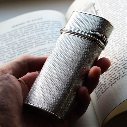 fig 8. An antique engine-turned solid silver cigar case featuring floral relief thumbpiece detailing and an engraved cartouche on the end.