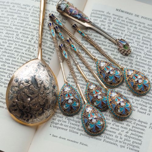 fig 4. Set of six antique Russian silver gilt spoons featuring blue, red, and white cloisonne enamel scrollwork on the backs of the teardrop-shaped bowls.