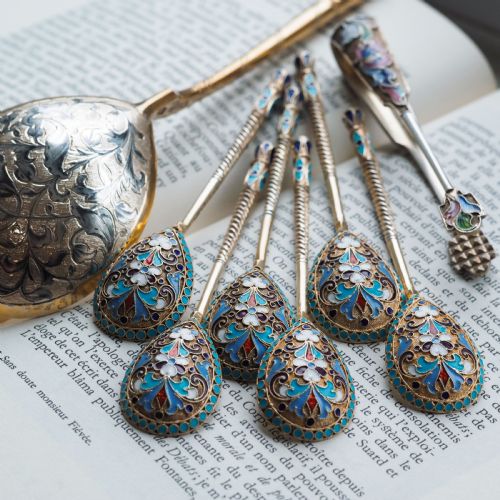 fig 5. Set of six antique Russian silver gilt spoons featuring blue, red, and white cloisonne enamel scrollwork on the backs of the teardrop-shaped bowls.