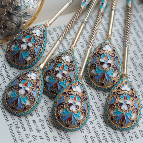 fig 6. Set of six antique Russian silver gilt spoons featuring blue, red, and white cloisonne enamel scrollwork on the backs of the teardrop-shaped bowls.