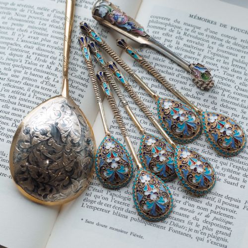 fig 7. Set of six antique Russian silver gilt spoons featuring blue, red, and white cloisonne enamel scrollwork on the backs of the teardrop-shaped bowls.