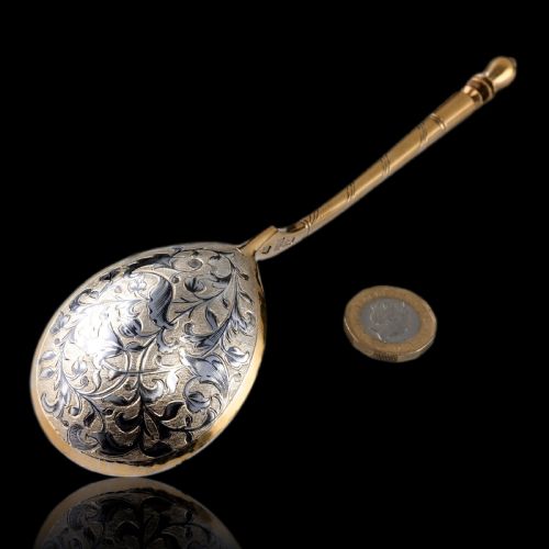 fig 1. An antique Russian silver-gilt serving spoon featuring intricate black niello foliate engraving across the back of the oval bowl and a turned stem.