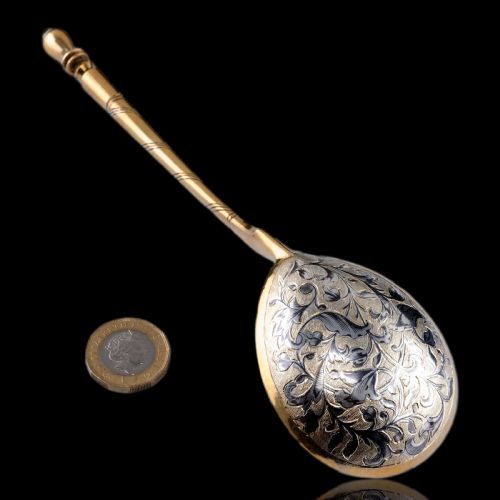 fig 2. An antique Russian silver-gilt serving spoon featuring intricate black niello foliate engraving across the back of the oval bowl and a turned stem.