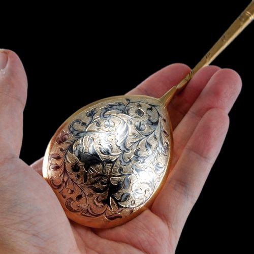 fig 4. An antique Russian silver-gilt serving spoon featuring intricate black niello foliate engraving across the back of the oval bowl and a turned stem.