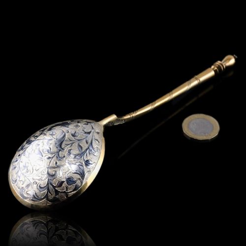 fig 7. An antique Russian silver-gilt serving spoon featuring intricate black niello foliate engraving across the back of the oval bowl and a turned stem.