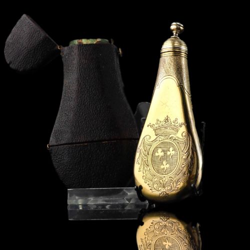 fig 1. A seventeenth-century teardrop-shaped silver gilt scent flask engraved with a coronet and crest, positioned alongside its dark leather case.
