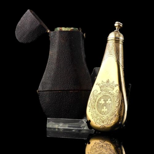 fig 2. A seventeenth-century teardrop-shaped silver gilt scent flask engraved with a coronet and crest, positioned alongside its dark leather case.