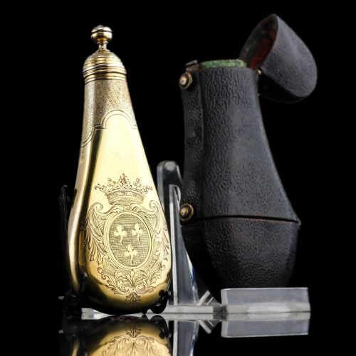 fig 3. A seventeenth-century teardrop-shaped silver gilt scent flask engraved with a coronet and crest, positioned alongside its dark leather case.