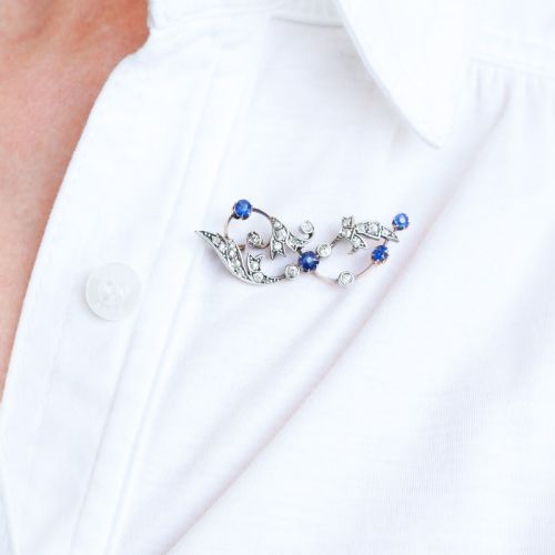fig 1. An antique Victorian foliate scroll brooch crafted in gold and silver, set with circular blue sapphires and accent diamonds.