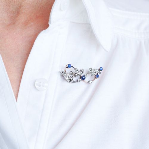 fig 4. An antique Victorian foliate scroll brooch crafted in gold and silver, set with circular blue sapphires and accent diamonds.