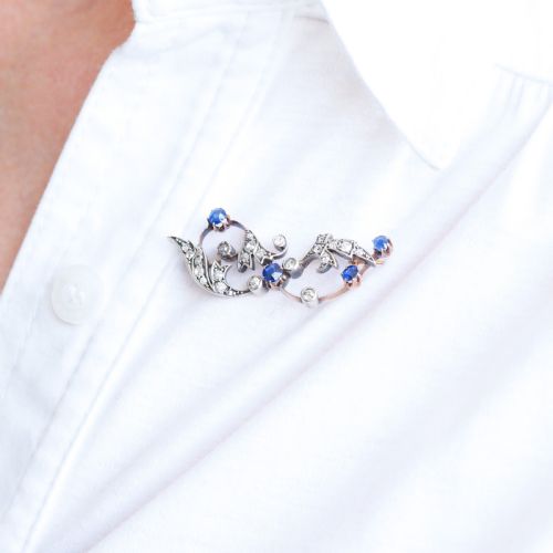 fig 6. An antique Victorian foliate scroll brooch crafted in gold and silver, set with circular blue sapphires and accent diamonds.