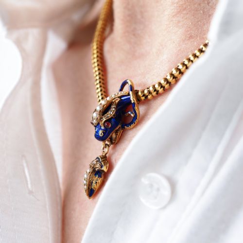 fig 6. A Victorian 18-carat gold woven chain necklace featuring a blue enamel snake head set with seed pearls, small diamonds, and ruby eyes.