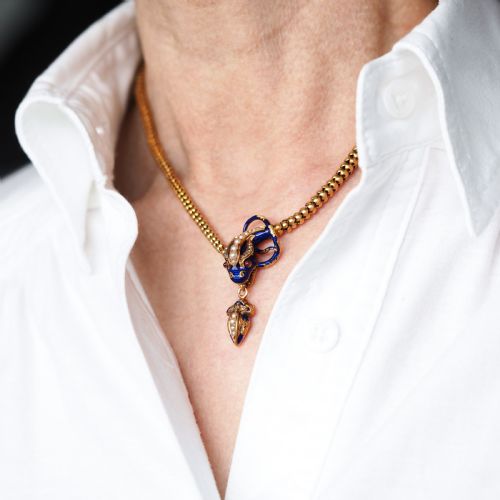 fig 7. A Victorian 18-carat gold woven chain necklace featuring a blue enamel snake head set with seed pearls, small diamonds, and ruby eyes.