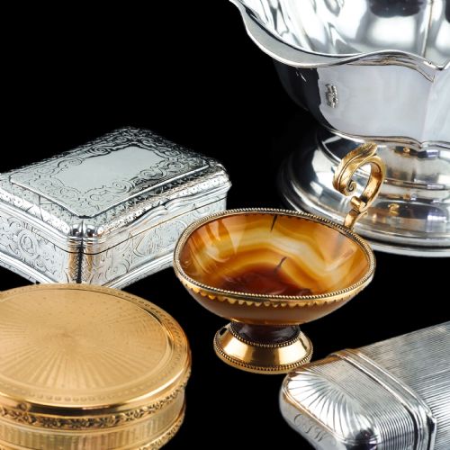 fig 7. A 19th-century carved brown banded agate cup featuring a silver-gilt rim, pedestal base, and an ornate scroll handle.