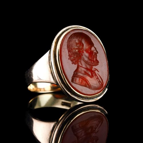 fig 2. An antique gold signet ring featuring an oval red carnelian gemstone carved with the side profile portrait of a gentleman.