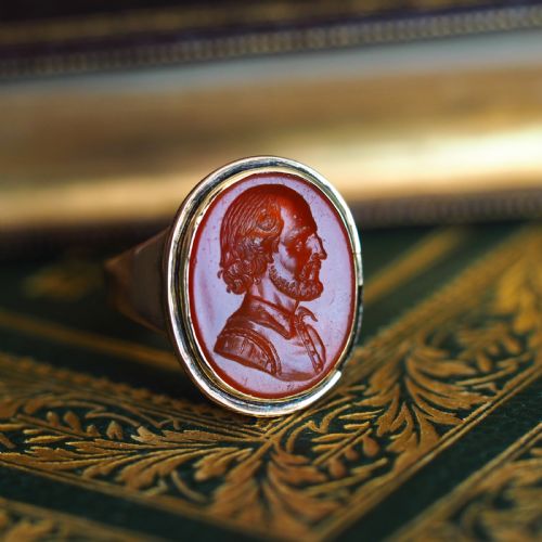 fig 7. An antique gold signet ring featuring an oval red carnelian gemstone carved with the side profile portrait of a gentleman.