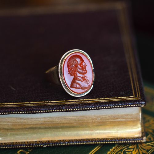 fig 8. An antique gold signet ring featuring an oval red carnelian gemstone carved with the side profile portrait of a gentleman.