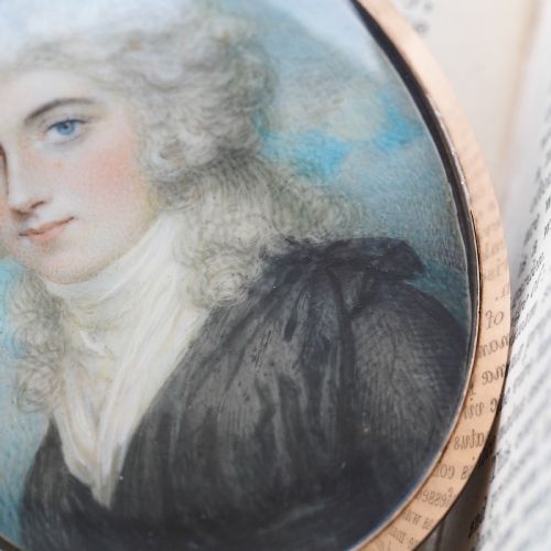 fig 5. An oval Georgian portrait miniature depicting a subject with light powdered hair set in a 14k gold frame with a top bail.