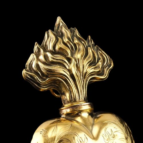 fig 2. A 19th-century French silver-gilt heart-shaped scent bottle featuring an engraved monogram, foliate scrollwork, and a flame-shaped stopper.