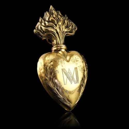 fig 3. A 19th-century French silver-gilt heart-shaped scent bottle featuring an engraved monogram, foliate scrollwork, and a flame-shaped stopper.