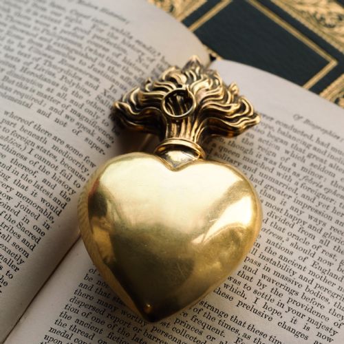 fig 6. A 19th-century French silver-gilt heart-shaped scent bottle featuring an engraved monogram, foliate scrollwork, and a flame-shaped stopper.
