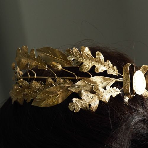 fig 1. A 19th-century silver gilt foliate crown featuring detailed oak leaves, acorns, laurel leaves, and a central ribbon bow medallion.