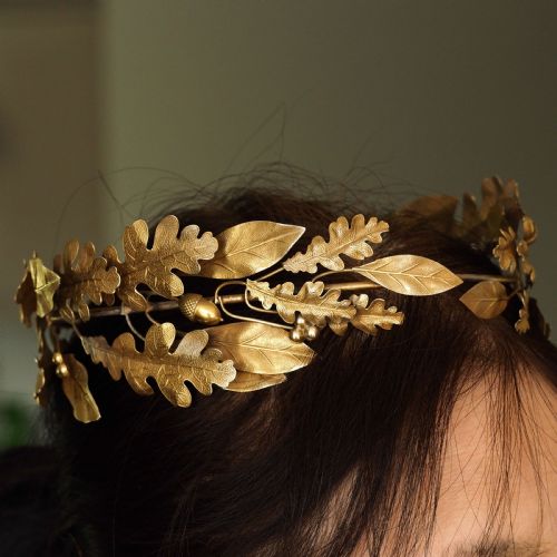 fig 3. A 19th-century silver gilt foliate crown featuring detailed oak leaves, acorns, laurel leaves, and a central ribbon bow medallion.