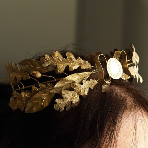 fig 5. A 19th-century silver gilt foliate crown featuring detailed oak leaves, acorns, laurel leaves, and a central ribbon bow medallion.