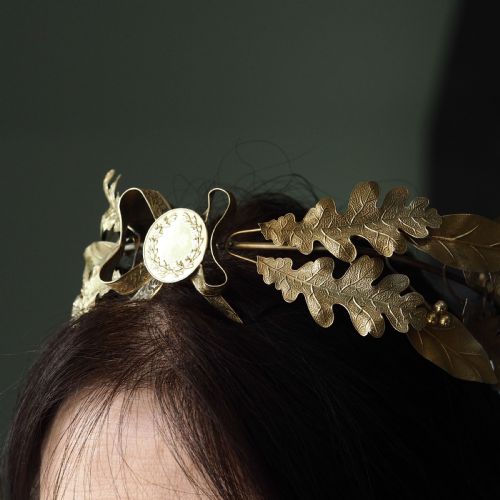 fig 6. A 19th-century silver gilt foliate crown featuring detailed oak leaves, acorns, laurel leaves, and a central ribbon bow medallion.