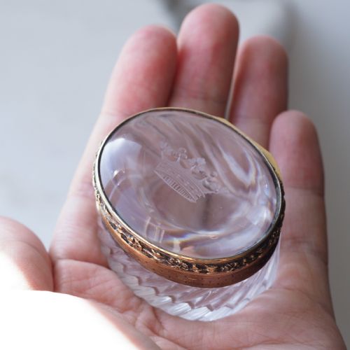 fig 7. An oval cut crystal box featuring a gilt silver rim and a transparent glass lid etched with a nobility coronet crest.