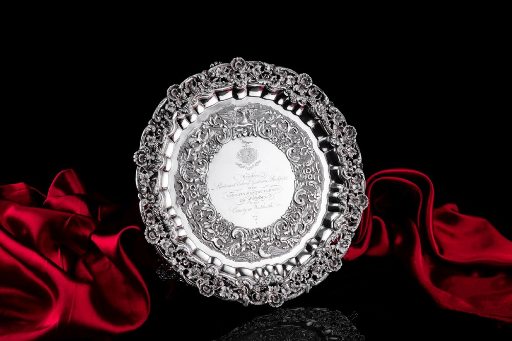A circular Georgian sterling silver salver featuring an intricately detailed cast floral border and central inscription engraving. View IV
