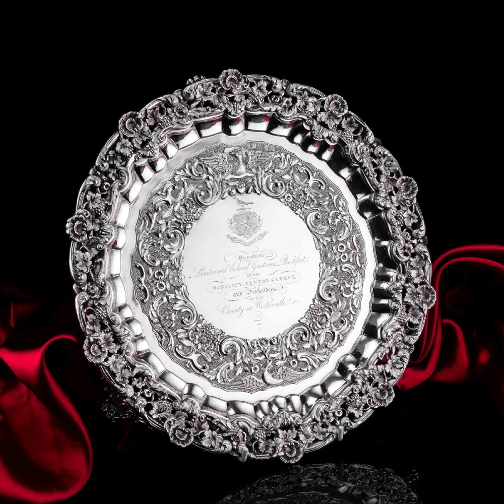A circular Georgian sterling silver salver featuring an intricately detailed cast floral border and central inscription engraving. View V