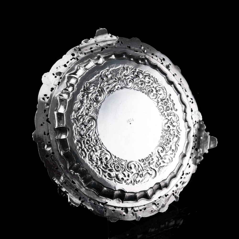 A circular Georgian sterling silver salver featuring an intricately detailed cast floral border and central inscription engraving. View VIII