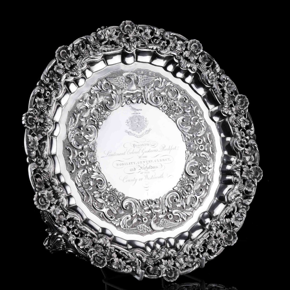 A circular Georgian sterling silver salver featuring an intricately detailed cast floral border and central inscription engraving. View IX