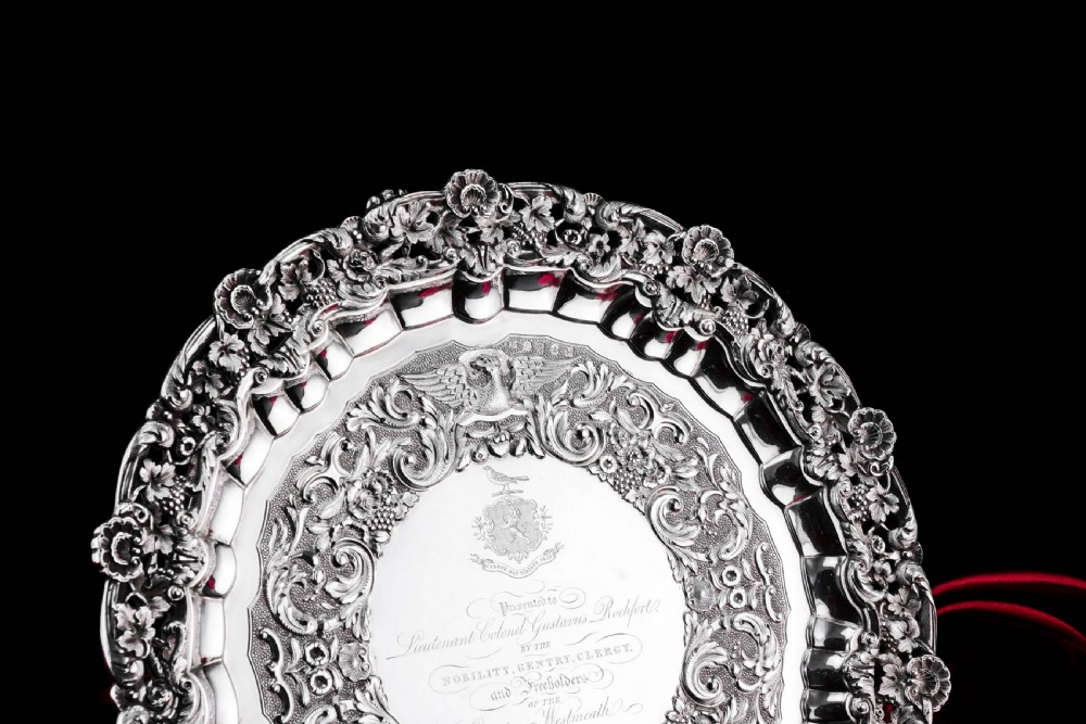 A circular Georgian sterling silver salver featuring an intricately detailed cast floral border and central inscription engraving. View XVII