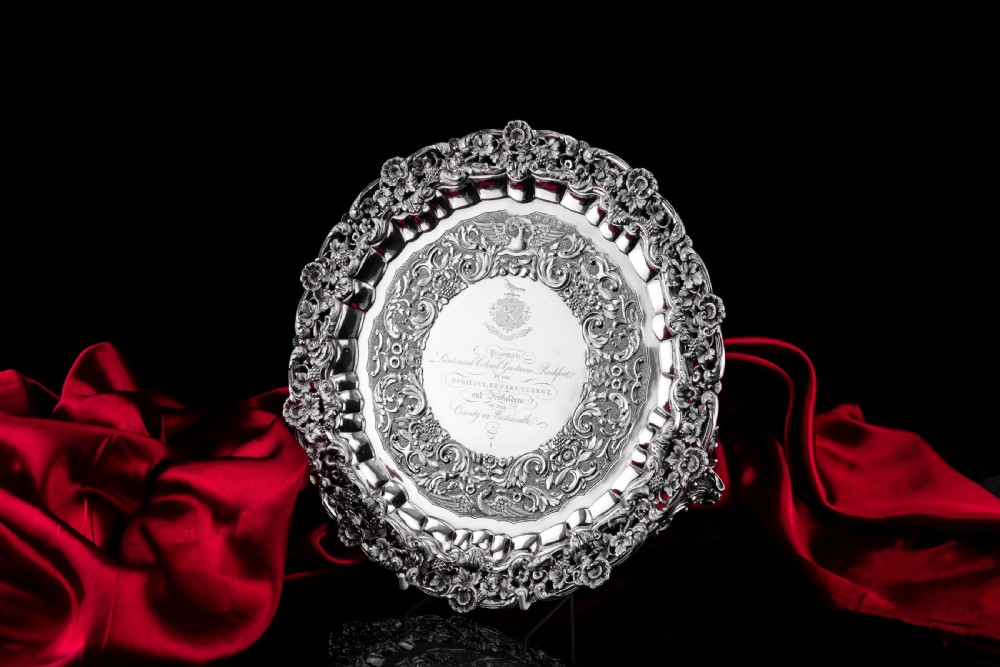 A circular Georgian sterling silver salver featuring an intricately detailed cast floral border and central inscription engraving. View XVIII