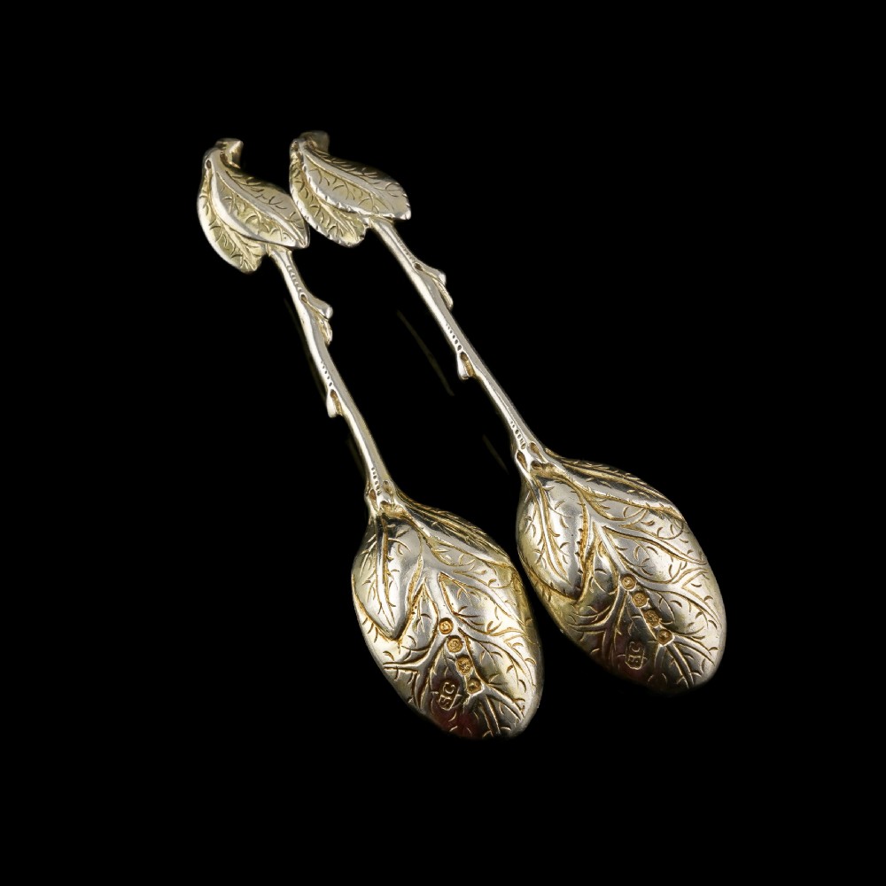A pair of Victorian silver-gilt serving spoons designed in a naturalistic motif with textured twig handles and leaf-engraved bowls. View IX