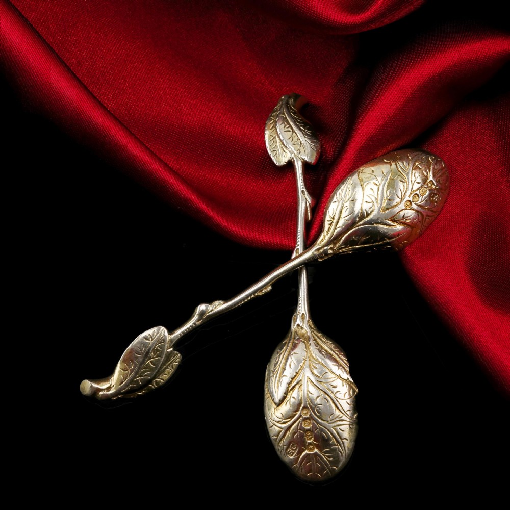 A pair of Victorian silver-gilt serving spoons designed in a naturalistic motif with textured twig handles and leaf-engraved bowls. View XI