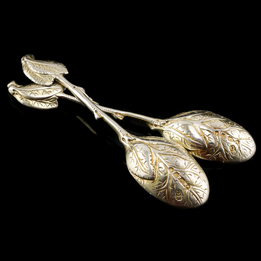 A pair of Victorian silver-gilt serving spoons designed in a naturalistic motif with textured twig handles and leaf-engraved bowls. View XII