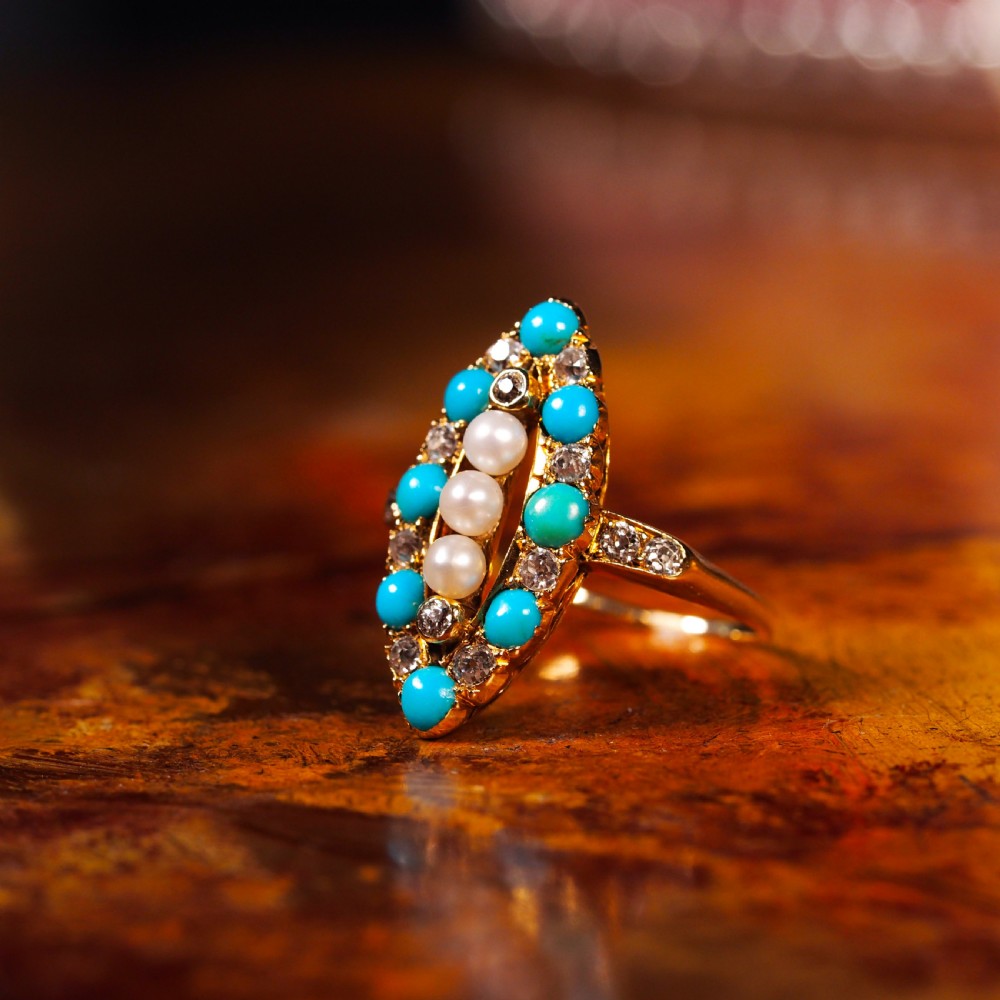 An antique Victorian 18ct yellow gold navette ring featuring three central pearls flanked by turquoise cabochons and old-cut diamonds. View XVI