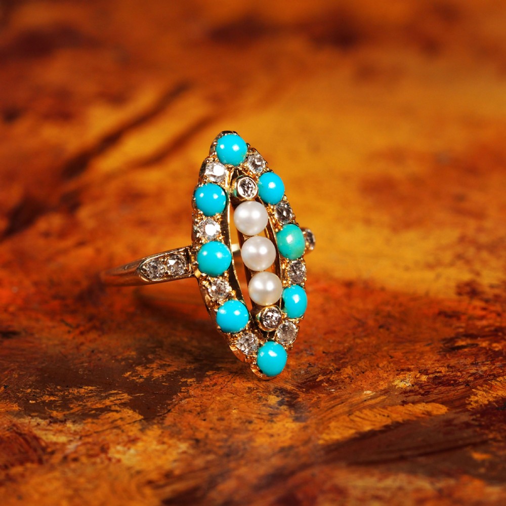 An antique Victorian 18ct yellow gold navette ring featuring three central pearls flanked by turquoise cabochons and old-cut diamonds. View XVIII