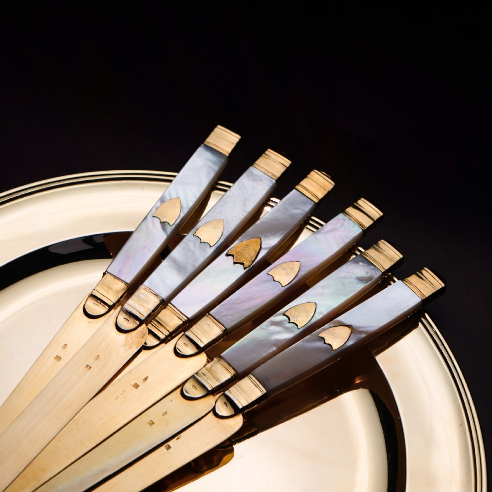 A set of six 19th-century fruit knives featuring silver-gilt blades and mother-of-pearl handles inlaid with small shield motifs. View III